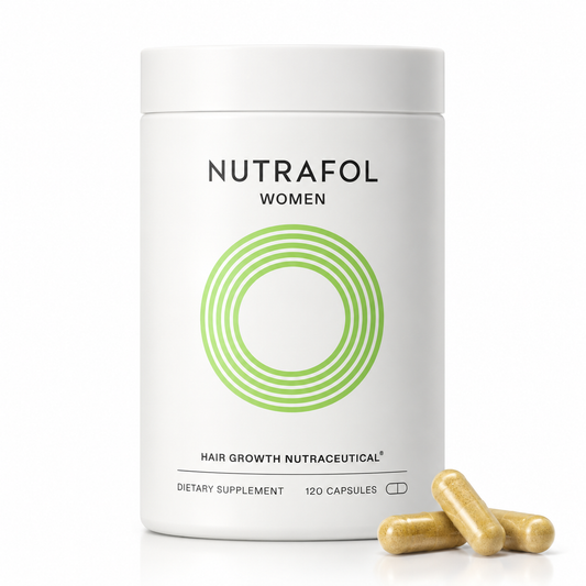 A white cylindrical bottle of Nutrafol Women dietary supplement with a green concentric circle logo, shown on a white background with three gold capsules in the foreground.